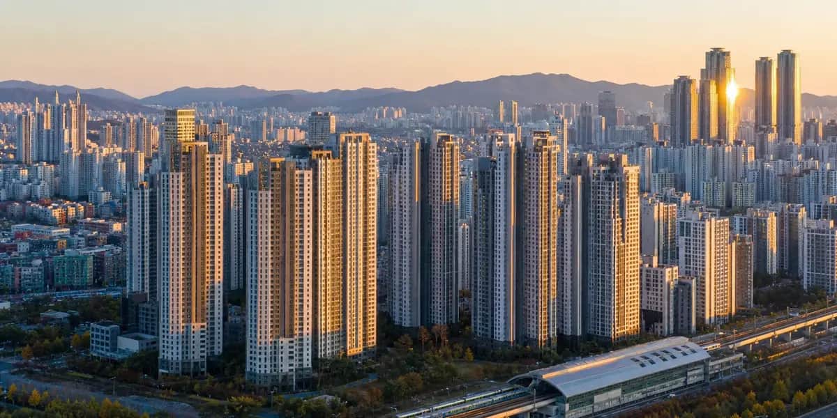 경기 남양주 다산신도시의 고층 아파트 단지들을 황금빛 노을 아래에서 항공 촬영한 다큐멘터리 스타일의 부동산 보도 사진으로, 밀집된 주거타워와 인근 교통 인프라의 분위기를 담은 이미지